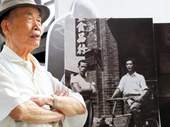 剝皮寮原住戶陳金春擺出與半世紀前影像同樣的姿勢。(台北市文化局提供)